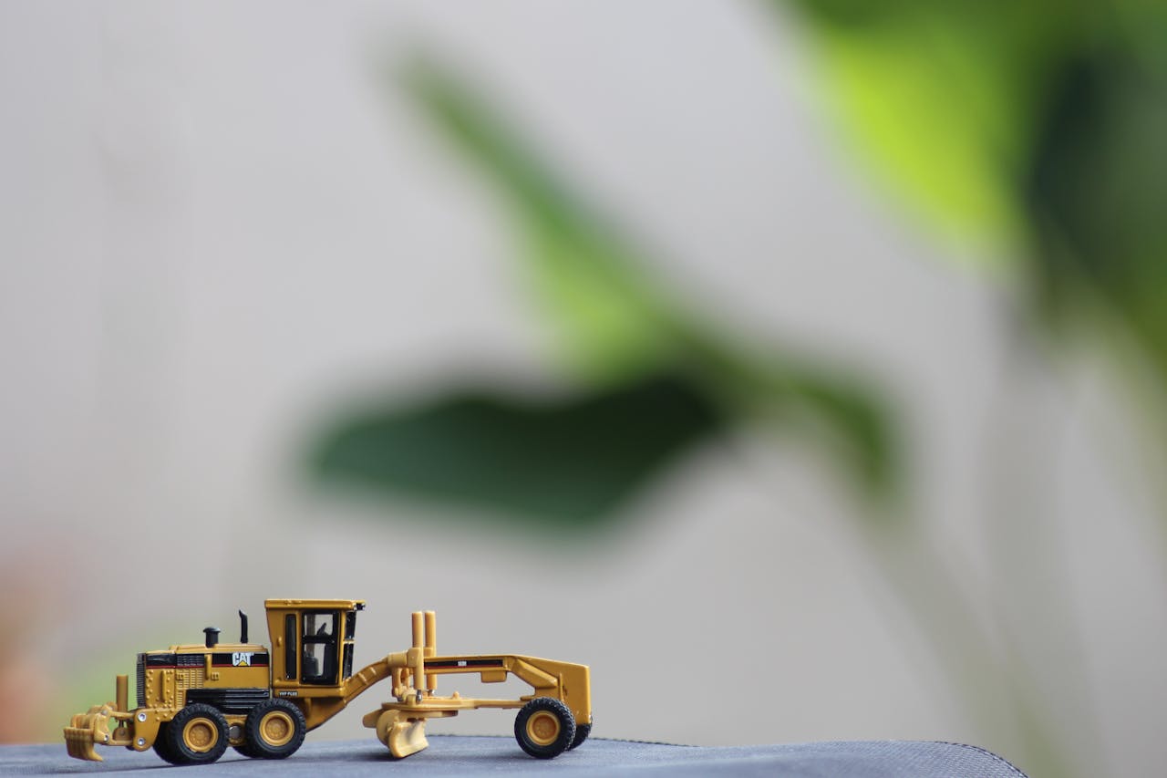 A detailed model of a construction vehicle against a blurred natural background.